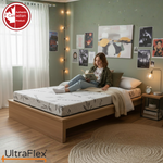 Person reading on an UltraFlex Atlas mattress in a bedroom with wall art and string lights.