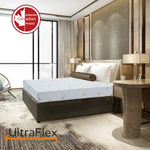 UltraFlex SleepTight mattress on a dark bed frame in a neutral bedroom with tall windows.
