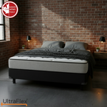 UltraFlex DreamWeaver mattress in a brick-walled bedroom with dark grey bedding.
