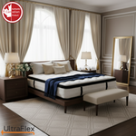 UltraFlex TruFirm mattress in a bedroom with cream curtains and navy bedding.