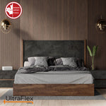 Bedroom with grey bedding, a dark upholstered headboard and warm wood-panelled walls.