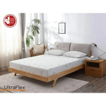 UltraFlex SolidSleep mattress on a wooden bed in a bright neutral bedroom.