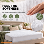 Hand touching the soft quilted surface of a Comfort Living jersey mattress protector.