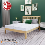 UltraFlex RestEasy mattress on a wood slat bed in a green bedroom, shown at an angle.
