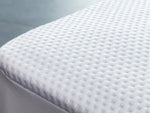 Close-up of the white textured surface of a Health Comfort mattress protector.