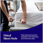 Person fitting a white mattress protector over a corner; elasticated pockets fit mattresses up to 18 inches deep.